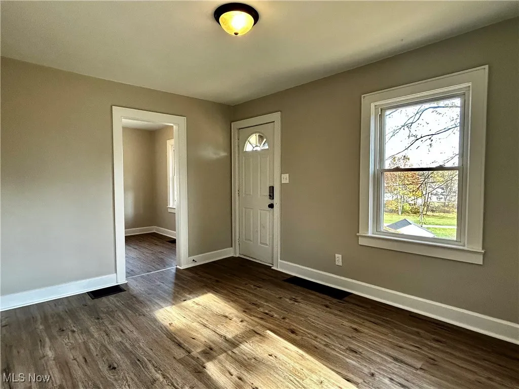 Entrance foyer with baseboards and dark wood finished floors