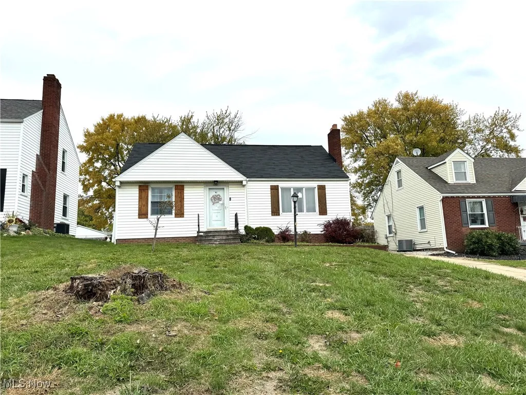 View of front of house with a front lawn, a chimney, and entry steps