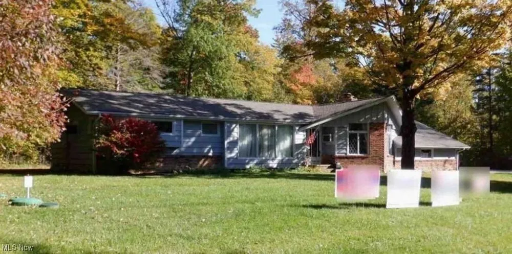 Rear view of property featuring a yard and brick siding