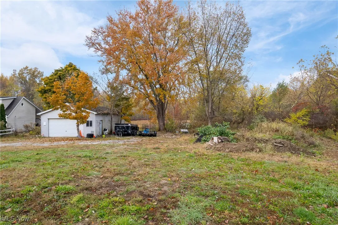 View of yard with a detached garage and view of wooded area