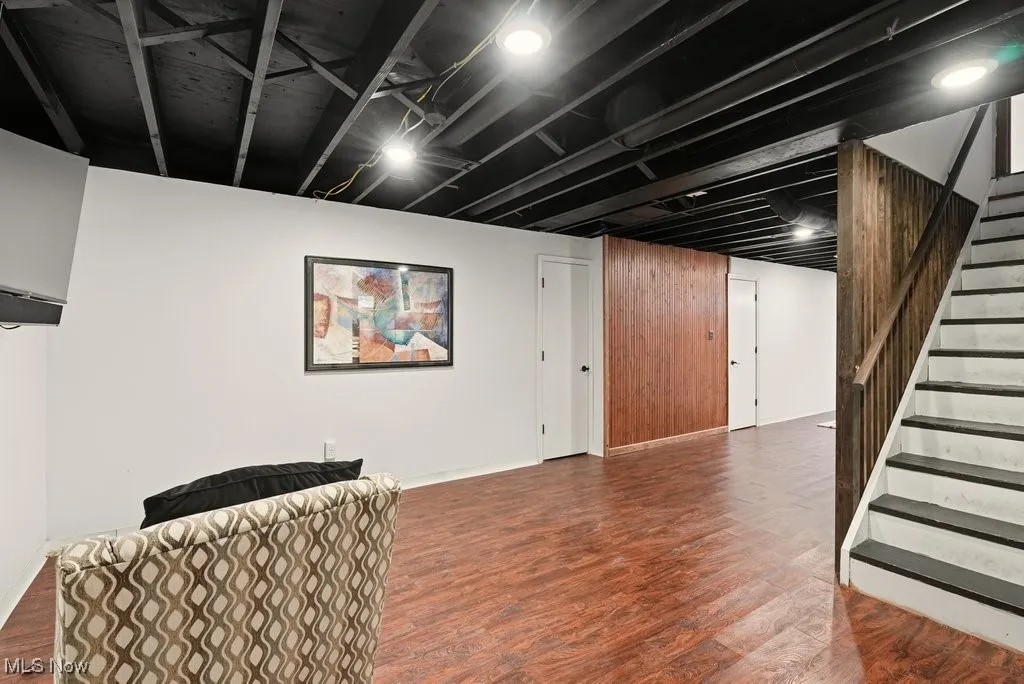 Finished below grade area featuring stairs and wood finished floors