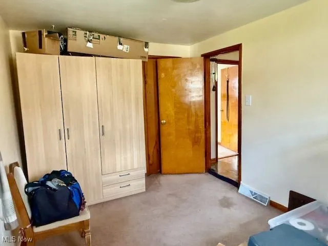 Unfurnished bedroom with a closet and light carpet