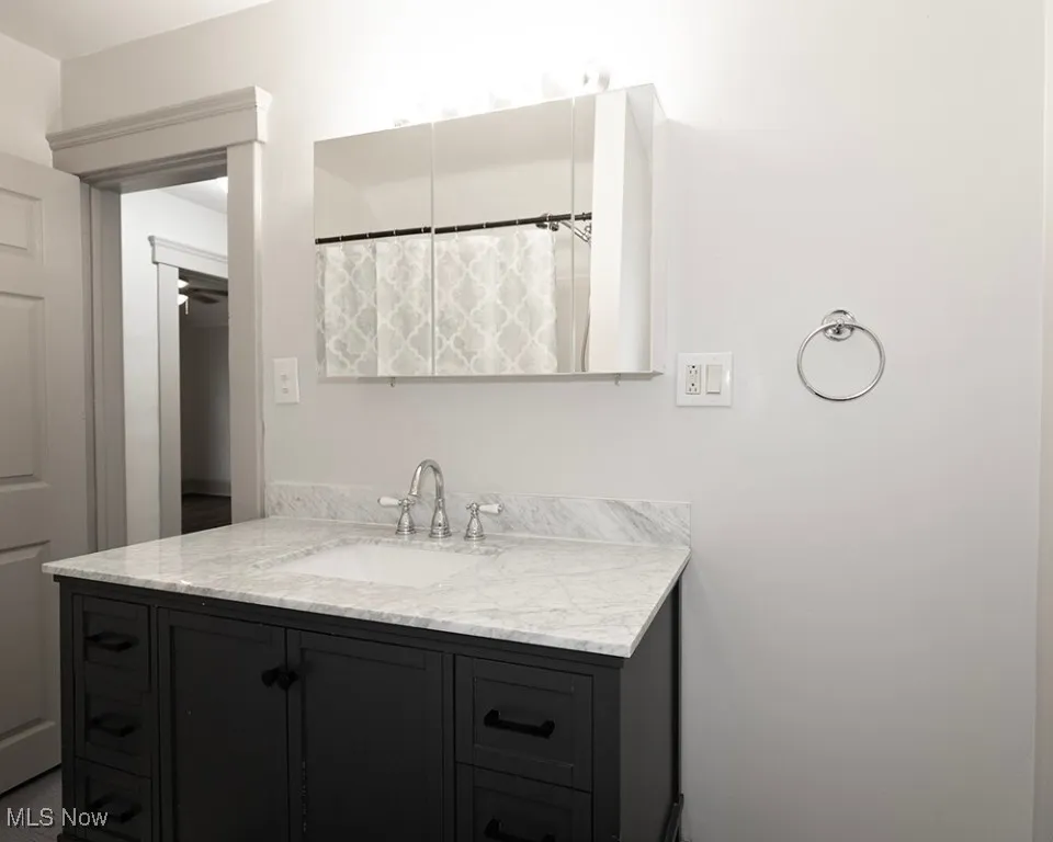 Full bathroom with vanity and curtained shower