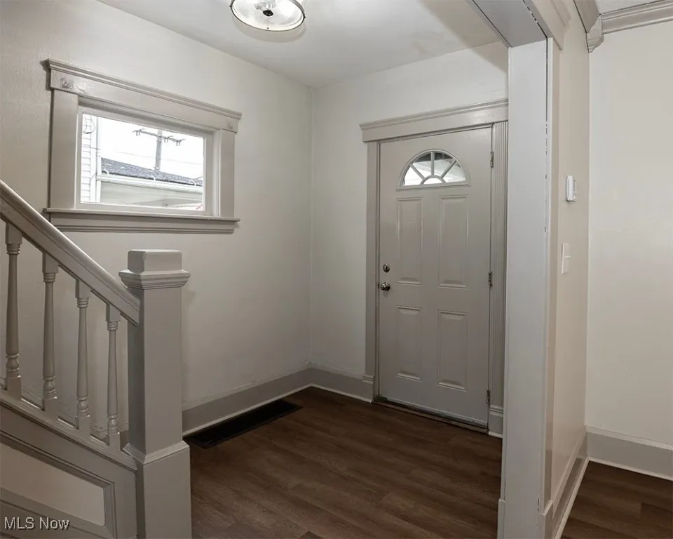 Foyer entrance featuring stairs and dark wood finished floors
