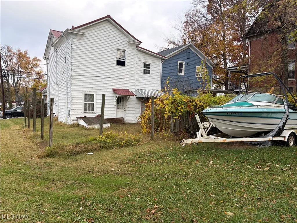 Rear view of property with a lawn