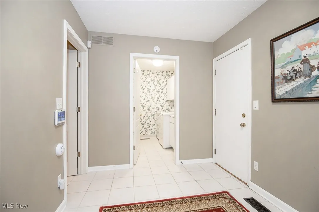 Entrance foyer with light tile patterned floors and washer / clothes dryer