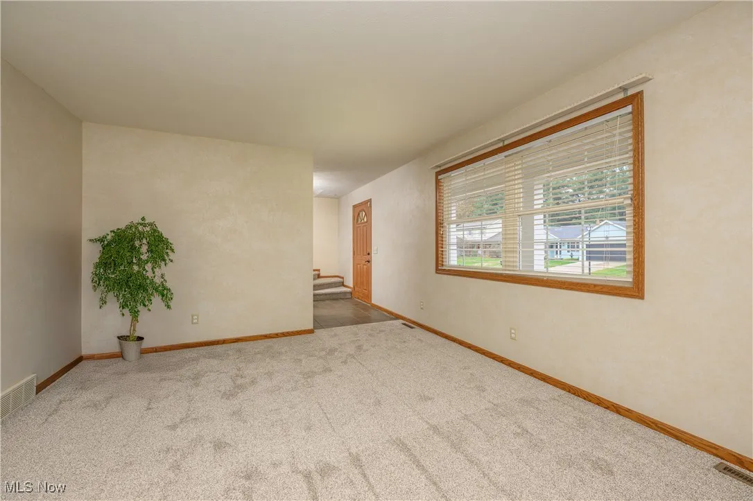 Empty room with baseboards and carpet