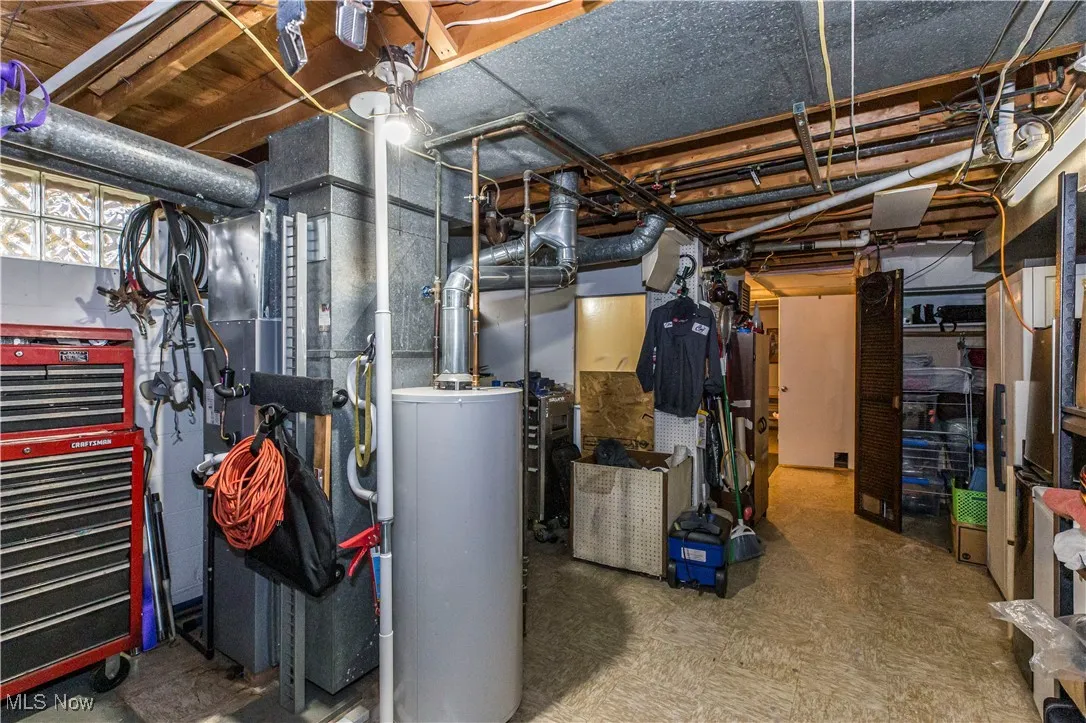 Utilities featuring water heater, heating unit, and lots of storage