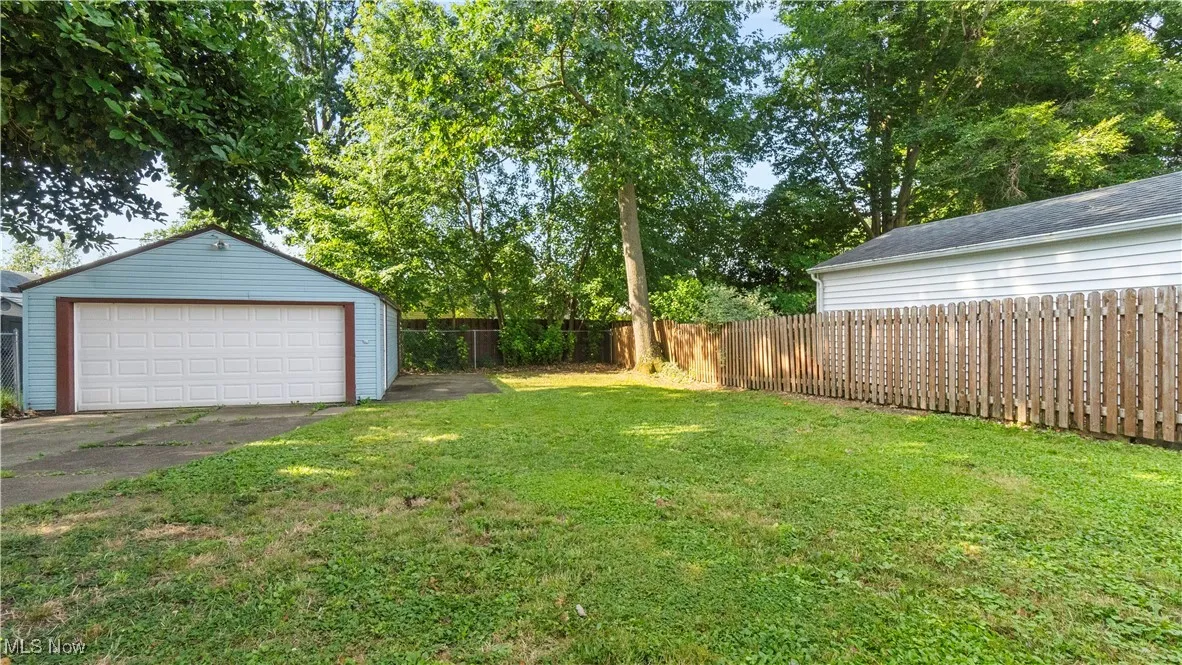 Fenced backyard with an outbuilding and a garage