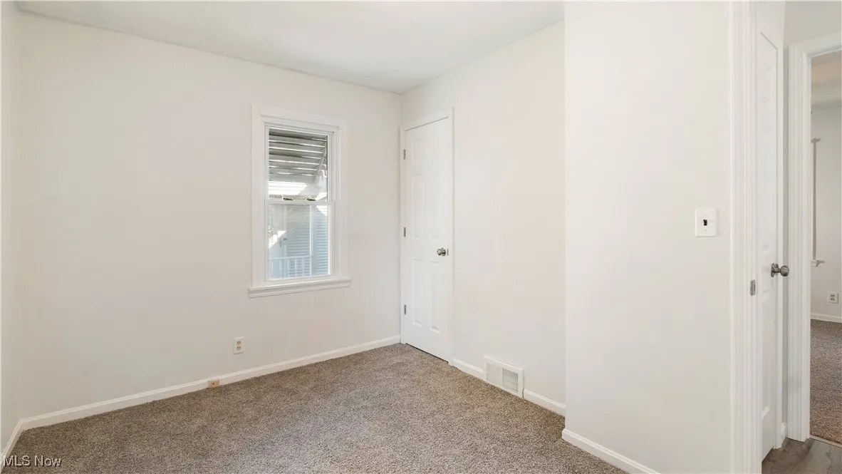 Unfurnished bedroom with carpet flooring and baseboards