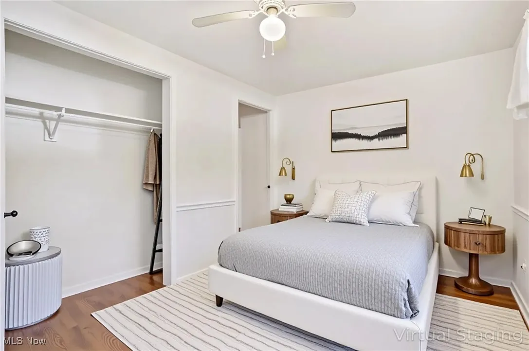 Bedroom with dark wood finished floors, ceiling fan, and a closet