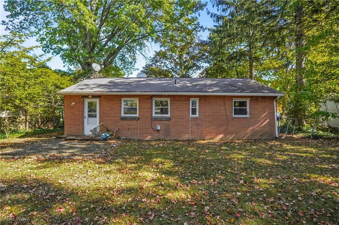 Rear view of house with a yard and brick siding