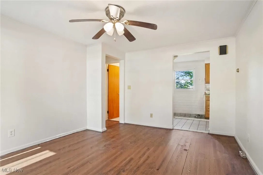 Empty room with dark wood finished floors and ceiling fan