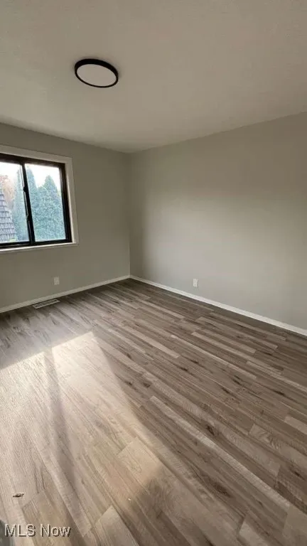 Unfurnished room with light wood-style floors and baseboards