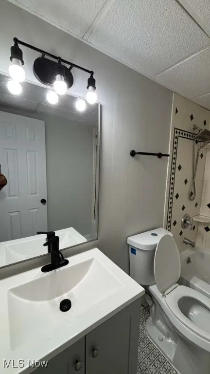 Bathroom featuring shower / washtub combination, vanity, and a textured ceiling