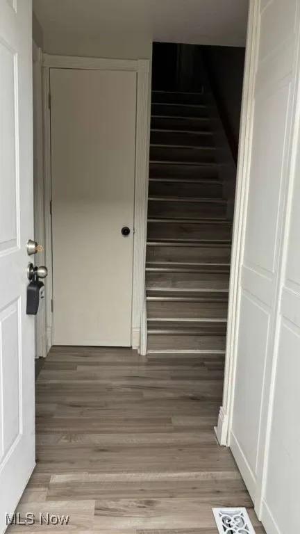 Stairs featuring wood finished floors