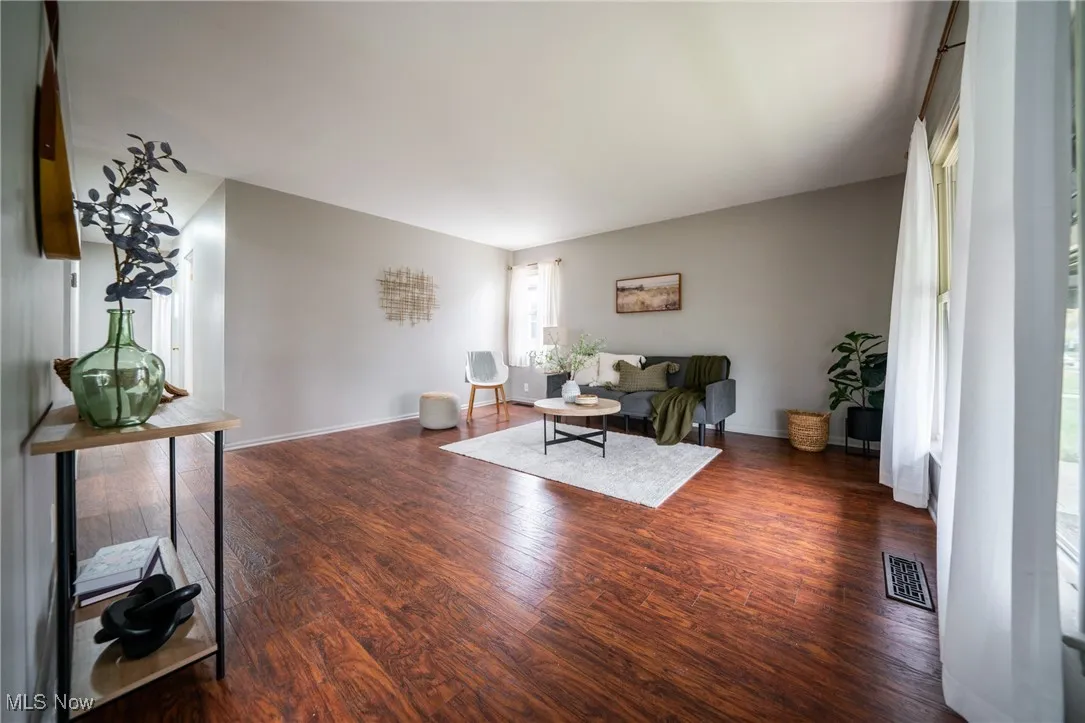 Living room with dark wood-style floors and baseboards