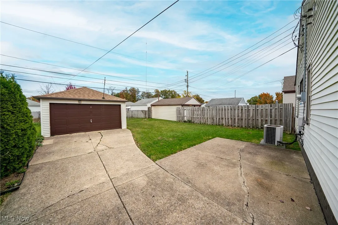 View of yard featuring an outbuilding, a garage, and a patio