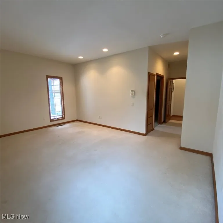 Empty room featuring recessed lighting and light carpet