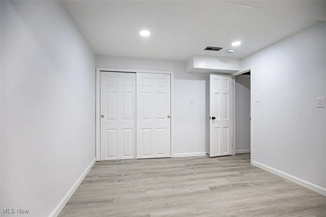 Unfurnished bedroom with light wood-style flooring, recessed lighting, and a closet