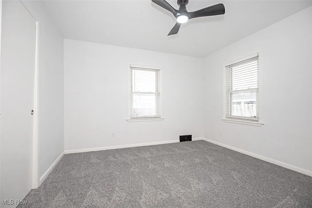 Carpeted bedroom with plenty of natural light and ceiling fan
