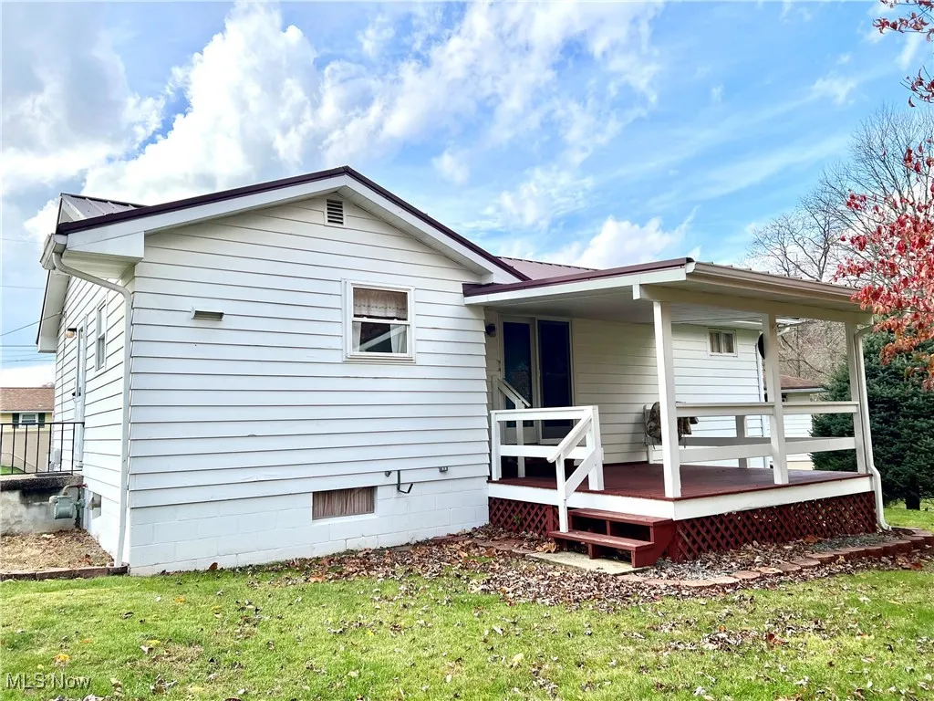 Rear view of property with a yard and a wooden deck