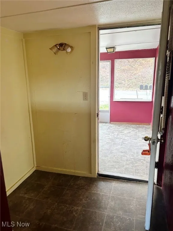Entryway featuring baseboards and a textured ceiling