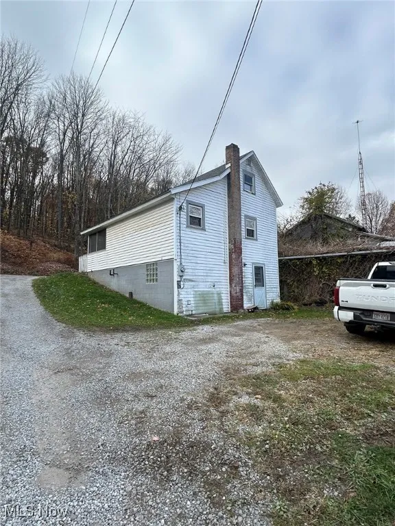 View of back of property featuring a chimney and a cooling unit