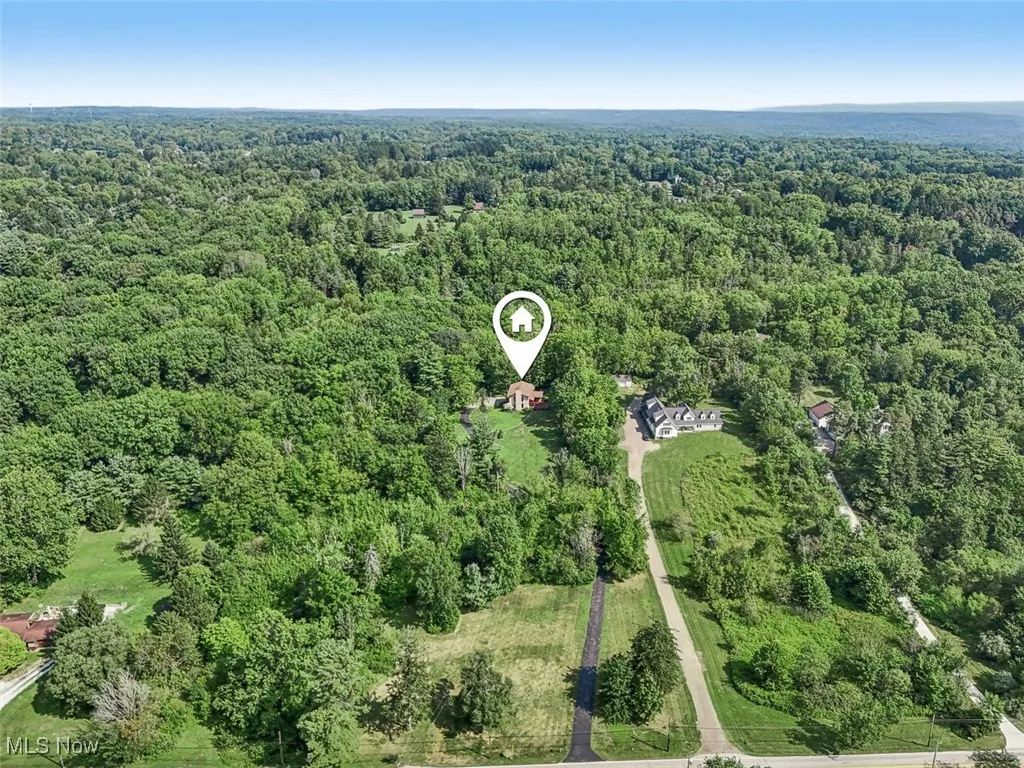 Aerial view of property's location featuring a heavily wooded area