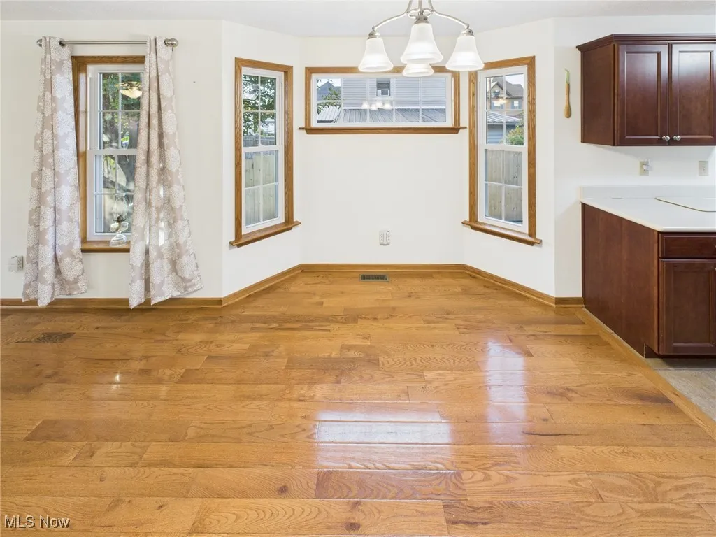 Unfurnished dining area with light wood-style floors and a chandelier