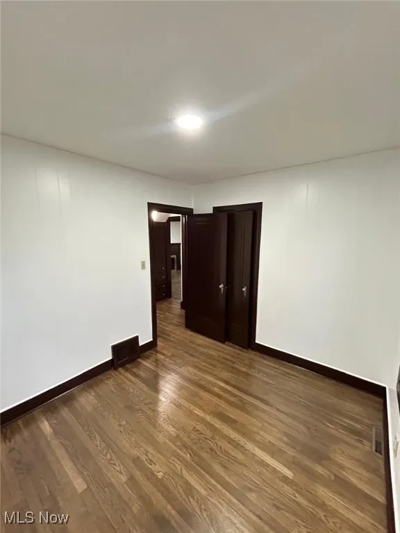 Spare room with dark wood finished floors
