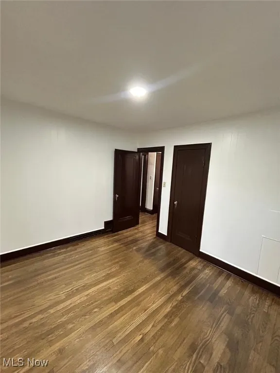 Spare room featuring dark wood finished floors