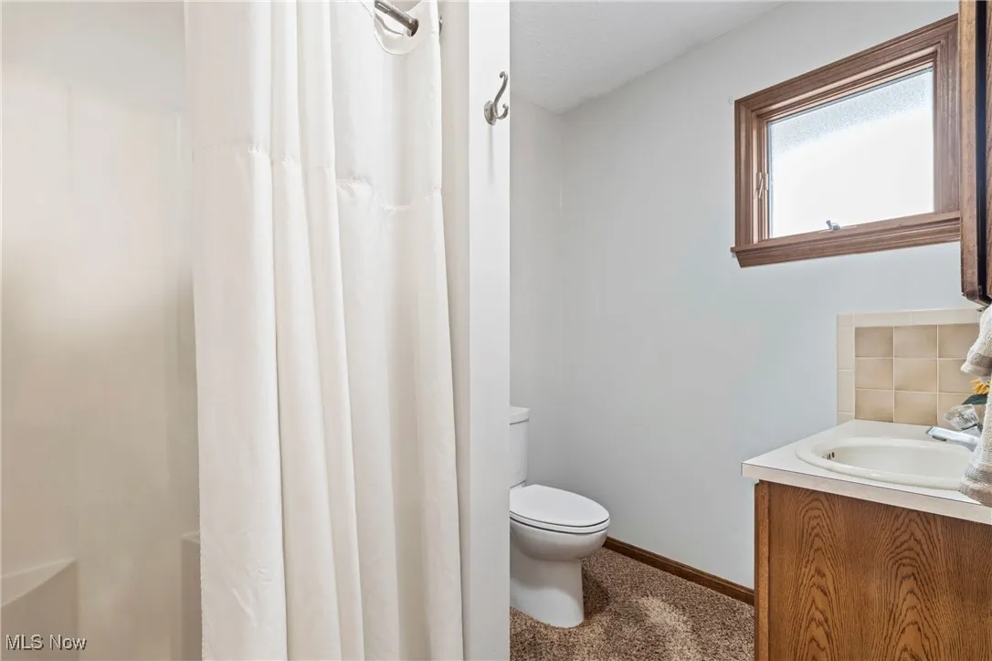 Full bath featuring vanity and curtained shower