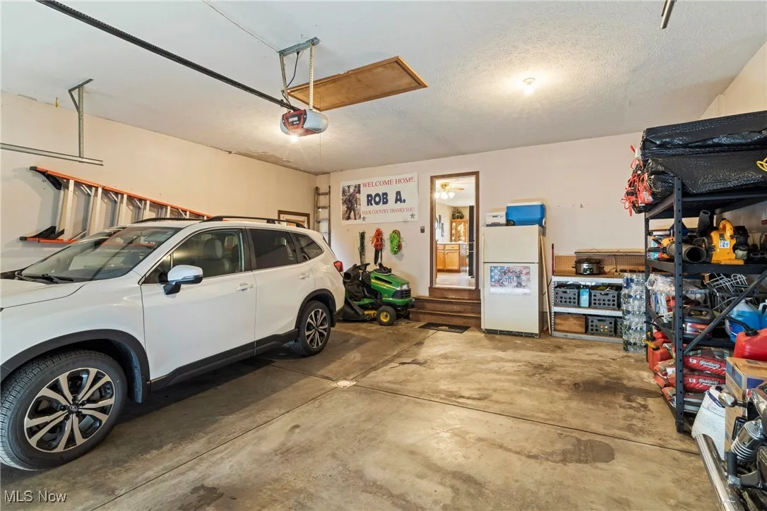Garage with freestanding refrigerator and a garage door opener