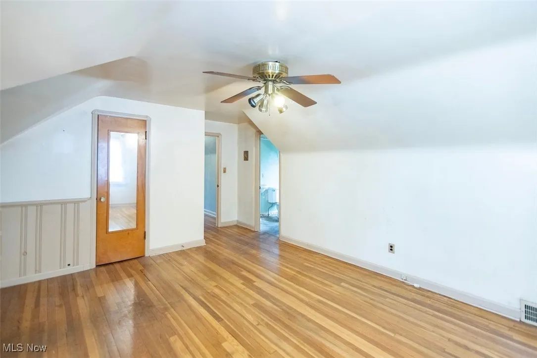 Second floor bedroom featuring light wood-type flooring and lofted ceiling