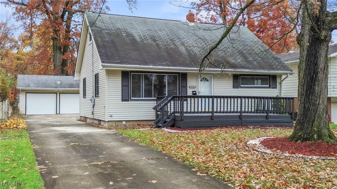 View of front of property featuring a double-car garage and a deck