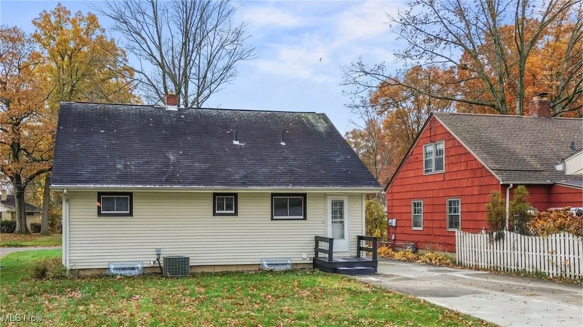 Back of property featuring a chimney and roof with shingles