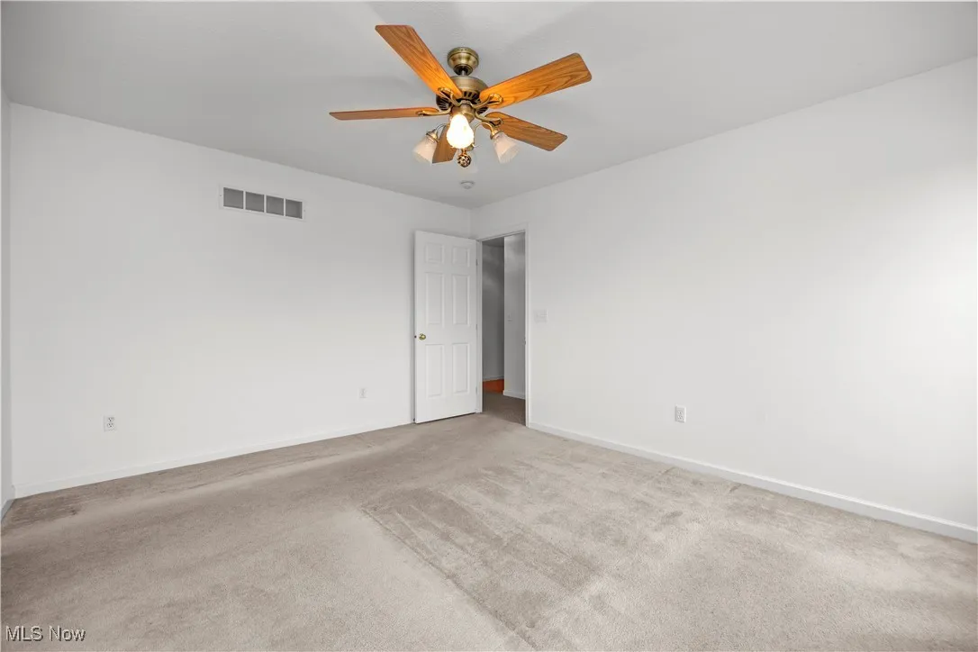 Spare room featuring carpet flooring and a ceiling fan