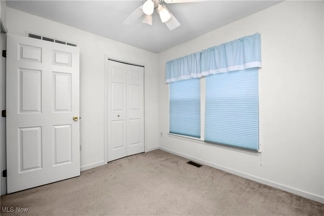 Unfurnished bedroom featuring carpet, ceiling fan, and a closet