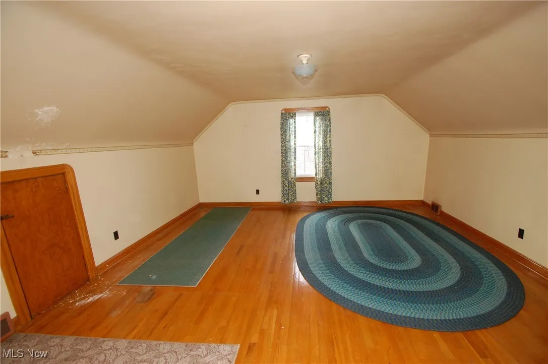 Bonus room featuring wood finished floors and vaulted ceiling