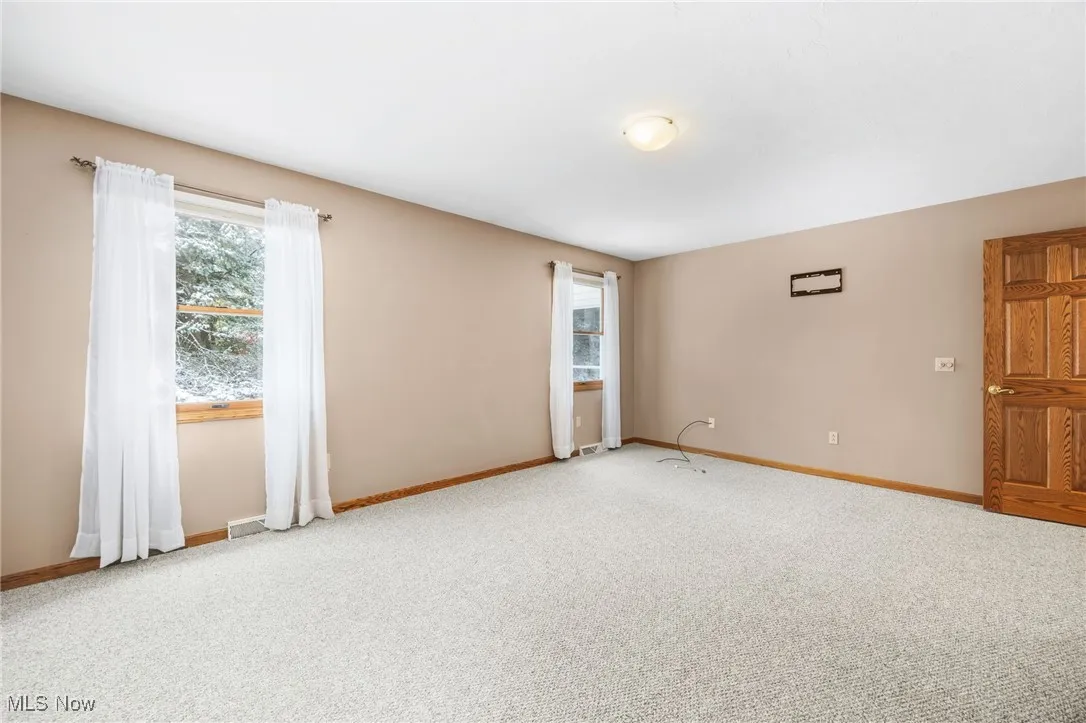 Empty room featuring baseboards and carpet floors