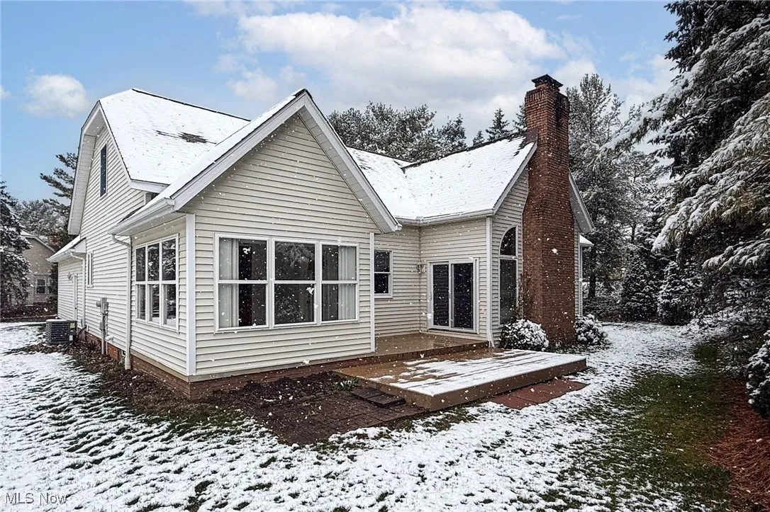 Snow covered house with a chimney and a deck