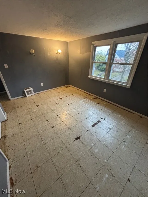 Spare room with tile patterned floors and a textured ceiling