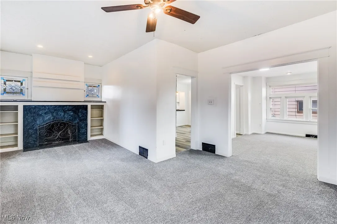 Unfurnished living room featuring light carpet, ceiling fan, and recessed lighting