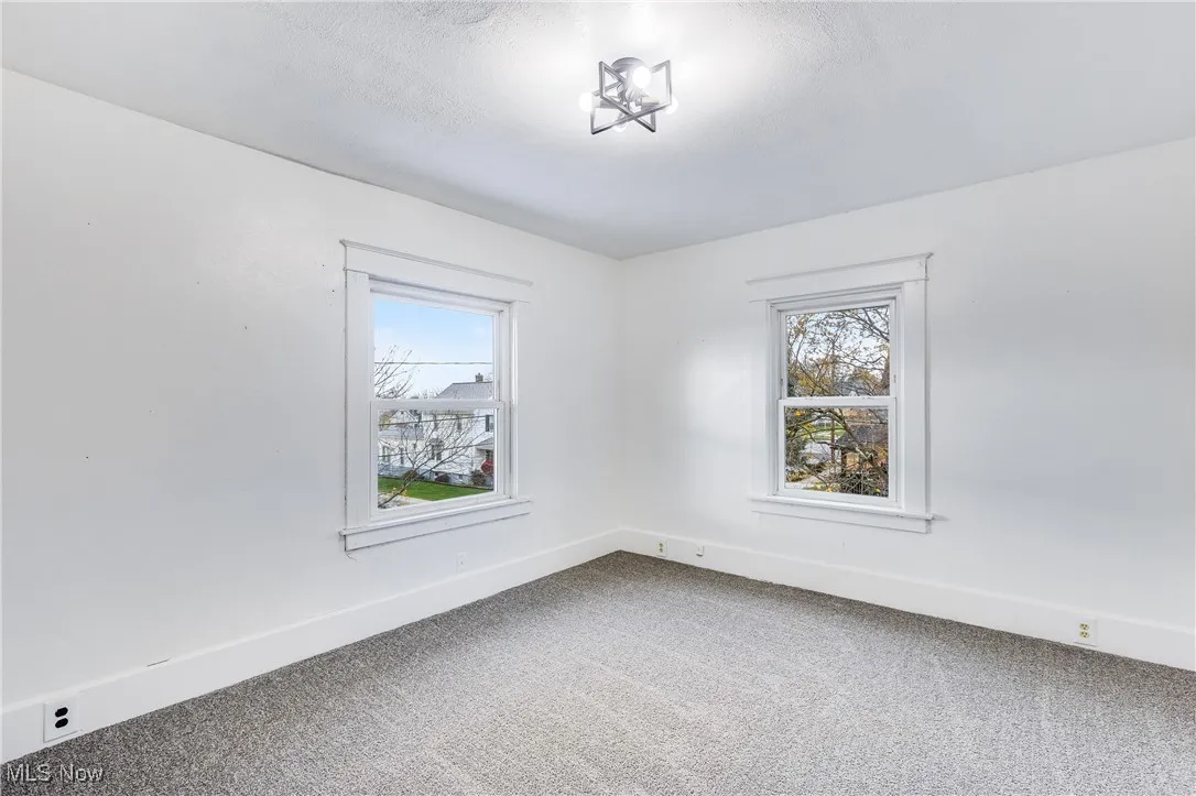 Empty room with carpet floors and baseboards