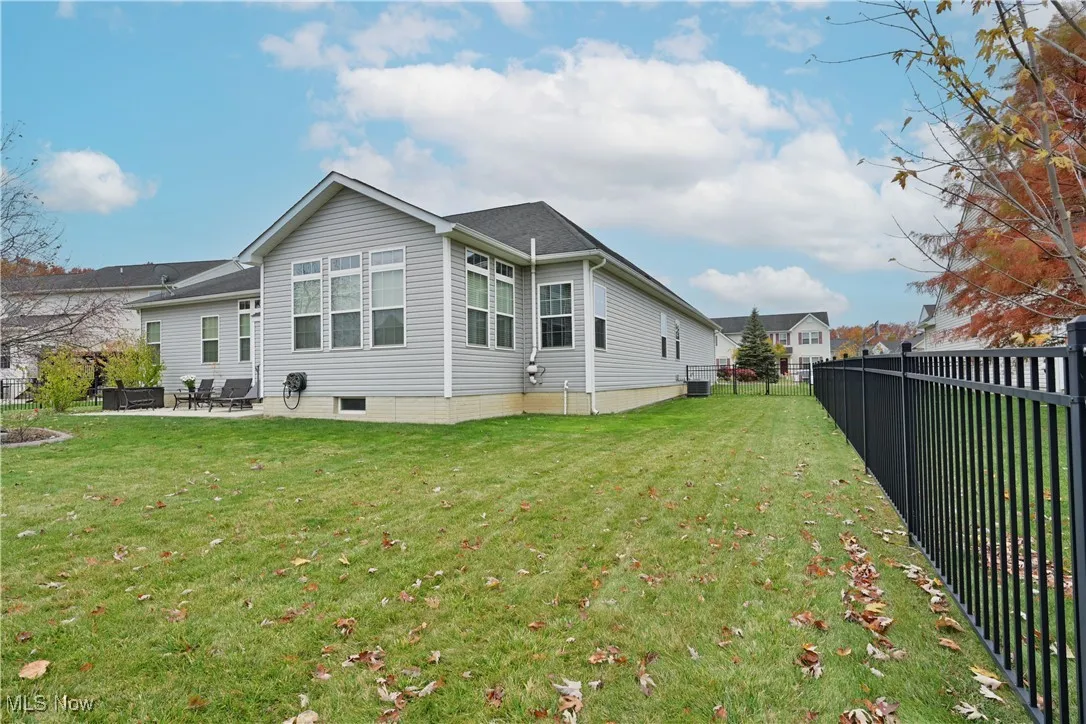 Back of house with a fenced backyard and a patio area