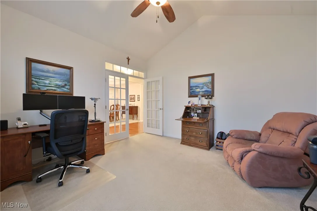 Office area with french doors, light colored carpet, ceiling fan, and high vaulted ceiling