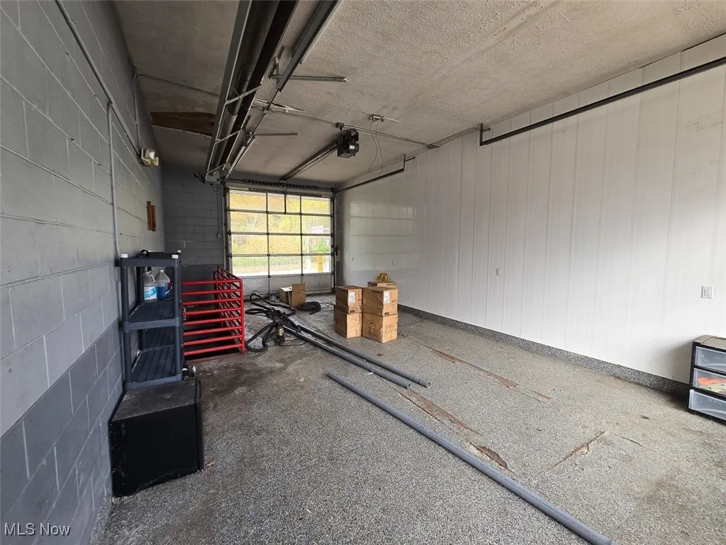 Garage featuring a garage door opener and concrete block wall