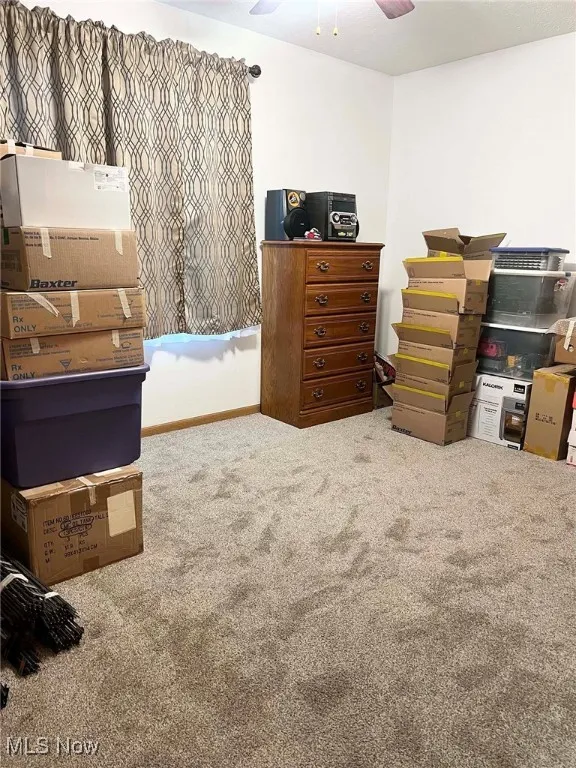 Bedroom with light colored carpet and a ceiling fan