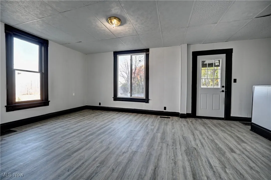 Empty room with light wood-type flooring and baseboards